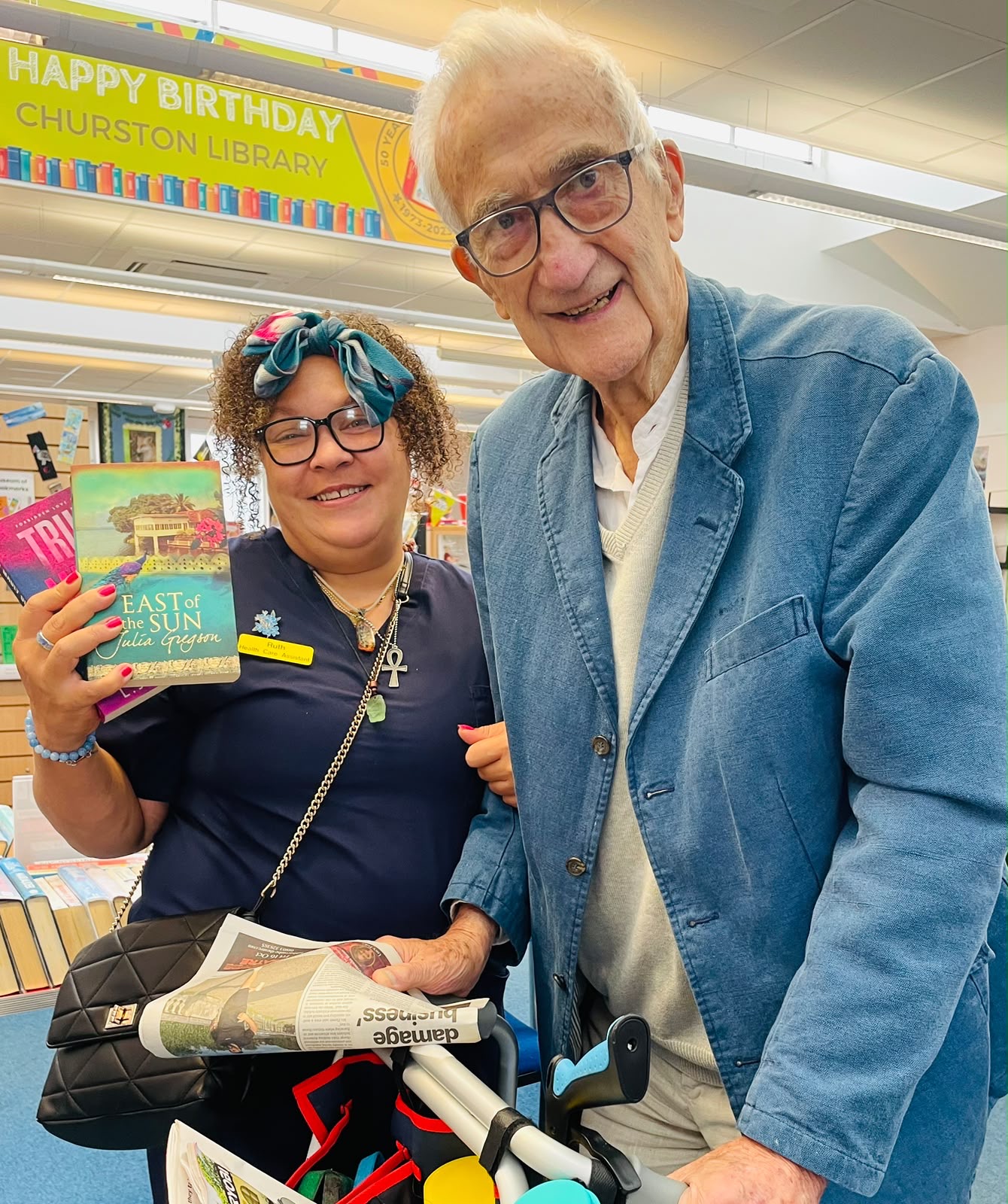 Churston Library trip A resident and carer holding books at Churston Library